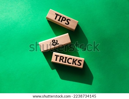 Tips and tricks symbol. Wooden blocks with words Tips and tricks. Beautiful green background. Business concept and Tips and tricks. Copy space.