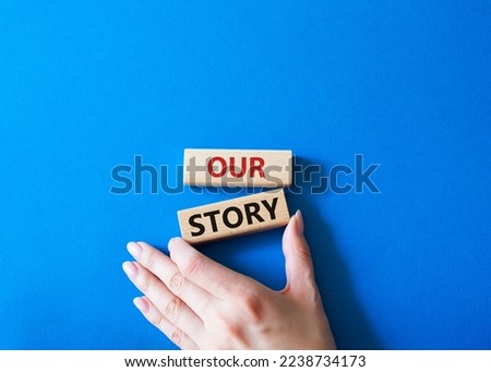 Our story symbol. Wooden blocks with words Our story Beautiful blue background. Businessman hand. Business and Our story concept. Copy space.