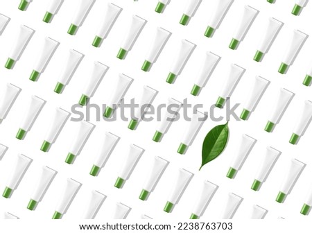 Creative seamless pattern of white cosmetic tubes and green leaf on white background. Cosmetics, skin care, beauty, body treatment concept. Creative design in flat lay style. Top view. Mock-up.