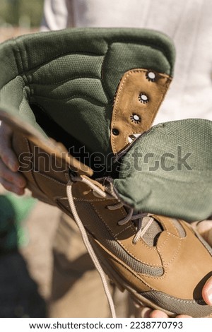 High-top lace-up sneakers in military color. The shoes are waterproof. Composition from the inside