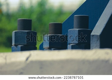 The blue bolts and nuts of the structure with large dimensions are made of high quality steel, high tensile steel which functions as an anchor to connect the pedestal foundation structure Royalty-Free Stock Photo #2238787101
