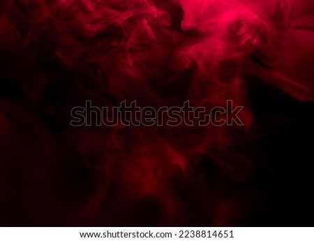 Abstract background of chaotically mixing puffs of red smoke on a dark background Royalty-Free Stock Photo #2238814651
