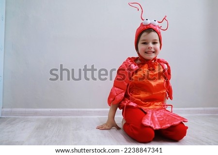 Children in smart carnival costumes on a plain background. Costume of sea fairy creatures. Mermaid and crab. Brother and sister.