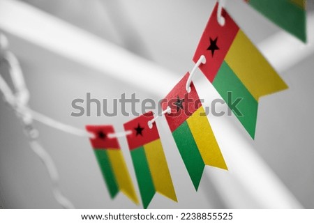 A garland of Guinea Bissau national flags on an abstract blurred background