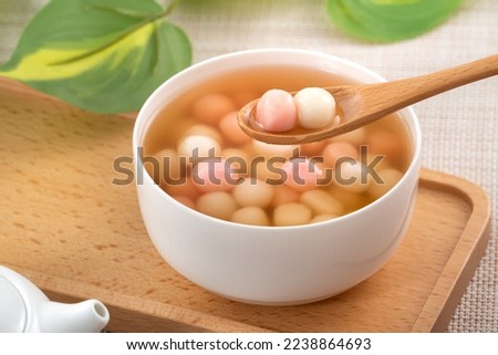 Little red and white tangyuan (tang yuan, glutinous rice dumpling balls) with sweet syrup soup in a bowl for Winter solstice festival food. Royalty-Free Stock Photo #2238864693