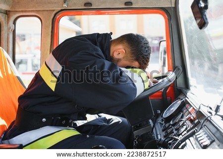 portrait of a firefighter driving a fire truck.