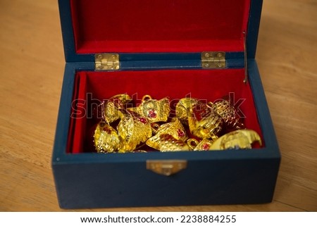 Lunar New Year decoration with lucky gold bar and red fish in the red box . Tet Holiday.Translation of text appear in image: fortune good luck	