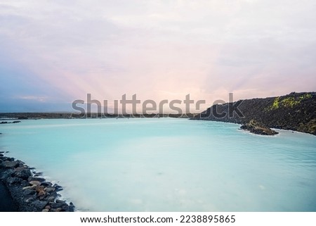 Blue lagoon in the sunset surrounded på lava rocks with green moss