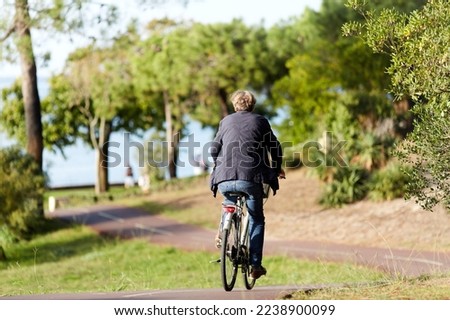man on a bicycle on the promenade by the beach