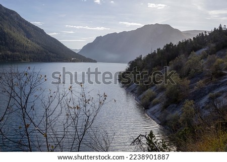 A view of a mountain alpine lake. Lake with hills, water and blue sky with clouds. Achensee in Tirol, Austria, beauty in nature