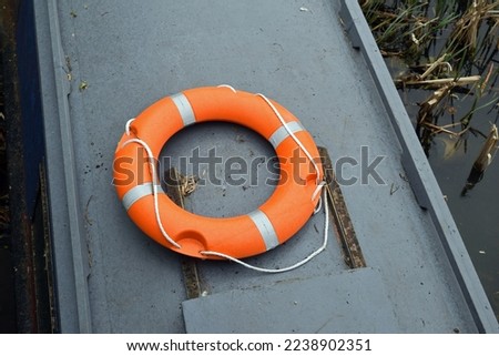Modern Orange Plastic Life Preserver with Rope on Top of Canal Barge  Royalty-Free Stock Photo #2238902351