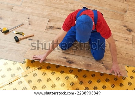 vinyl floor installation. Close-up hands of worker at home flooring renovation. Royalty-Free Stock Photo #2238903849