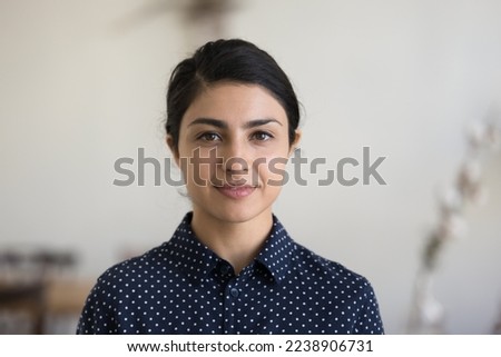 Positive beautiful young Indian woman in casual shirt looking at camera, smiling. Confident pretty 30s freelance businesswoman corporate head shot female business portrait Royalty-Free Stock Photo #2238906731