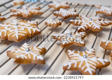 Christmas Cookies in Shape of Stars with Icing and Pearls. Snowflake Cookies for Santa Clause. Freshly Baked Snowflake Cookies on Coking Wire Rack Royalty-Free Stock Photo #2238921797