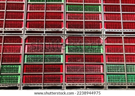 Plastic crates, red and green fruit and vegetable crates in truck's bed.