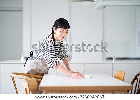 Young woman wiping the dining table Royalty-Free Stock Photo #2238949067