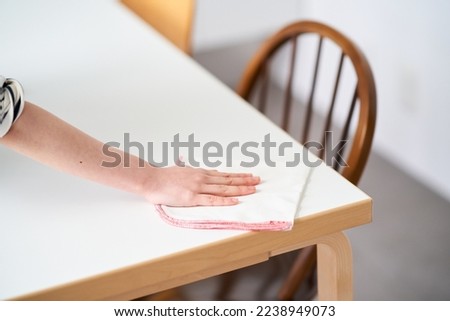 Young woman wiping the dining table Royalty-Free Stock Photo #2238949073