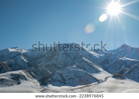 beautiful glare of the sun illuminates snowcapped mountains. panoramic view. Winter. beautiful clear blue sky in daylight. impressive view of the mountain peaks Royalty-Free Stock Photo #2238976845