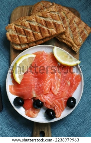 Salted salmon fillet with lemon and olives.