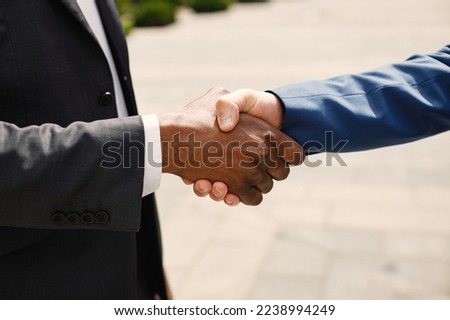 Cropped photo of business people shaking hands outdoors