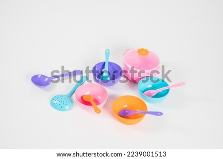 A set of multi-colored children's plastic utensils for games on a white background.