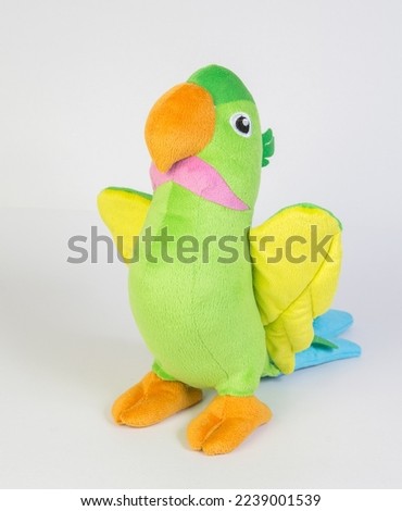 Bright plush colorful parrot. Soft children's toy on a white background.