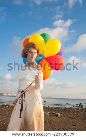 girl with colorful balloons on the beach