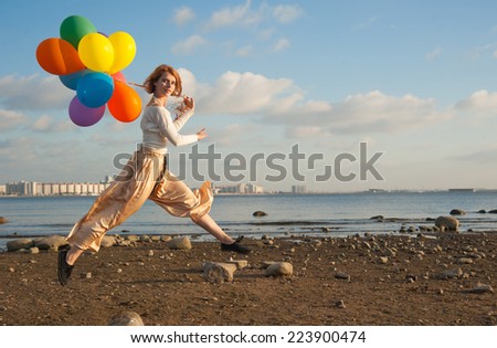 	  young Jennie jumping on the beach with balloons