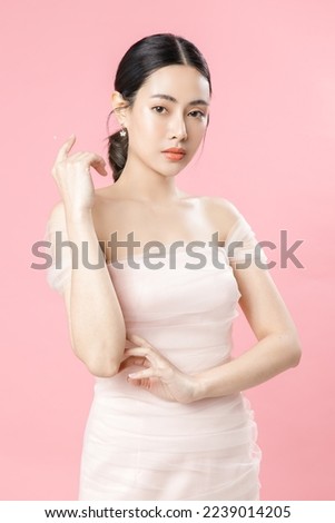 Asian woman with a beautiful face and Perfect clean fresh skin. Cute female model with natural makeup and sparkling eyes on pink isolated background. Facial treatment, Cosmetology, beauty Concept. Royalty-Free Stock Photo #2239014205