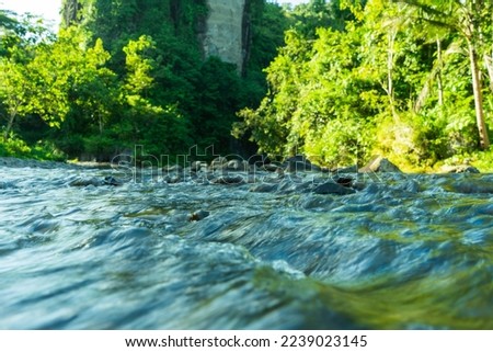 Streams of water between mountain stones in close-up. Beautiful alpine river stream with fast running water and pebbles. Flowing water in a gorgeous scene. Beautiful river rapids. Royalty-Free Stock Photo #2239023145