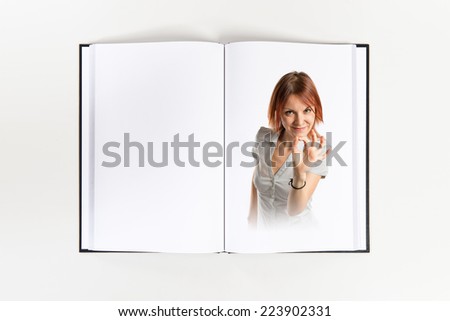 Pretty young girl with thumbs up printed on book