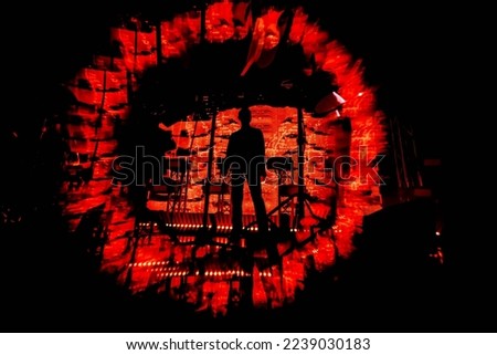 Eye of sauron. A silhouette of a band. A music show. A rock group concert