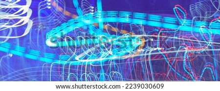 Long exposure photography. Abstract white light trails. Play with neon light beams. Suitable as beautiful winter festive bright background. Blue shades. Violet, blue, white. Creative amazing pattern