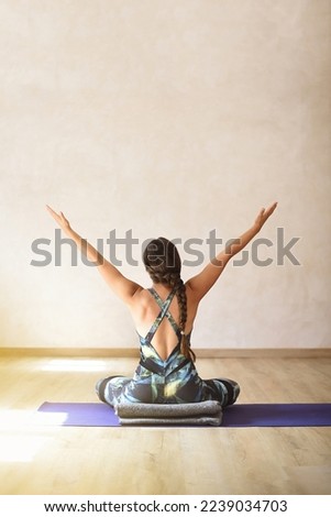 Woman sitting on her back in yoga room with raised arms Royalty-Free Stock Photo #2239034703