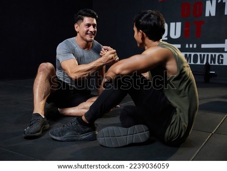 young athletic men meeting in the gym and shaking hands after workout Royalty-Free Stock Photo #2239036059