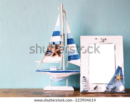 vintage nautical frame with wooden boat on the table. retro filtered image