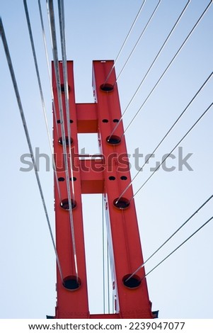 Red modern suspension bridge. Sun day. Construction 