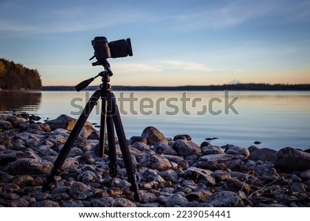 Professional camera on tripod at shore.