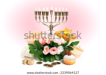 Image of Jewish holiday Hanukkah with menorah (traditional Candelabra), donuts, wooden dreidels (spinning top), chocolate coins, flowers and gift wrappings