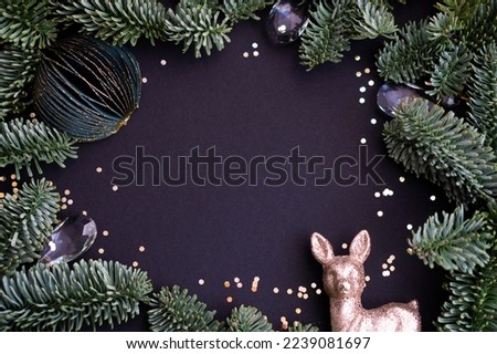 Christmas frame made of fir branches and Christmas decorations on a dark background with space for text. Top view. christmas glamor