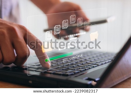Transfer files data system relocation with internet cloud technology concept. Person hand using laptop computer waiting for transfer file process with loading bar icon on virtual screen. Royalty-Free Stock Photo #2239082317
