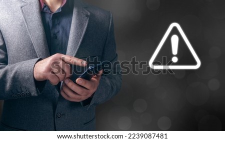 Warning sign in a triangle. Man tapping on phone screen