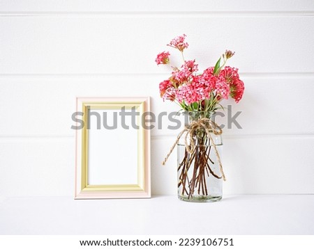 Flowers in vase with photo frame ,Empty picture frame mock up for presentation design Template framing fee modern art ,orchids in vase Lettering Text Message Copy space Blank for design Product 