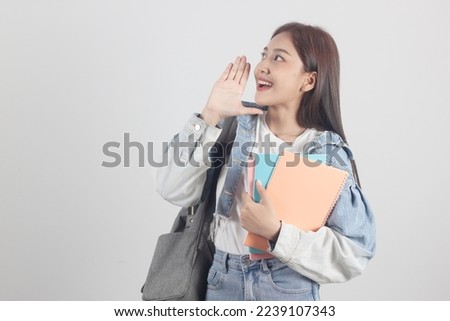 

Cheerful smiling Asian female college student with books and backpack on white background.