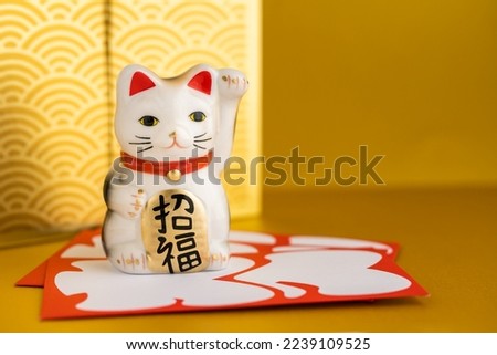 
A lucky cat figurine. In Japan, it is called manekineko. It is written as good luck in Japanese. Royalty-Free Stock Photo #2239109525