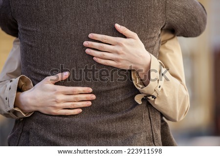 adult couple standing on street and hugging. closeup of woman hands hugging man outside Royalty-Free Stock Photo #223911598