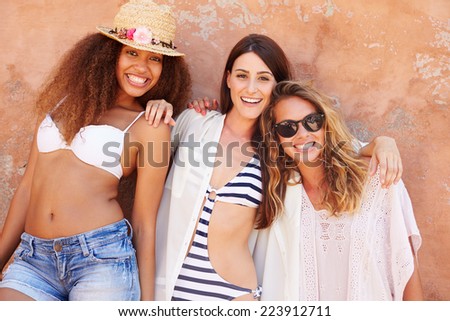Group Of Female Friends On Holiday Together Posing By Wall