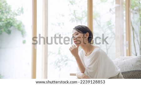 Depressed Asian middle aged woman in the room. Royalty-Free Stock Photo #2239128853