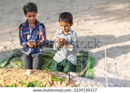 sad orphan children praying at their mother's grave