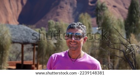 Portrait of a happy caucasian man hiking along the australian outback on a beautiful sunny day.